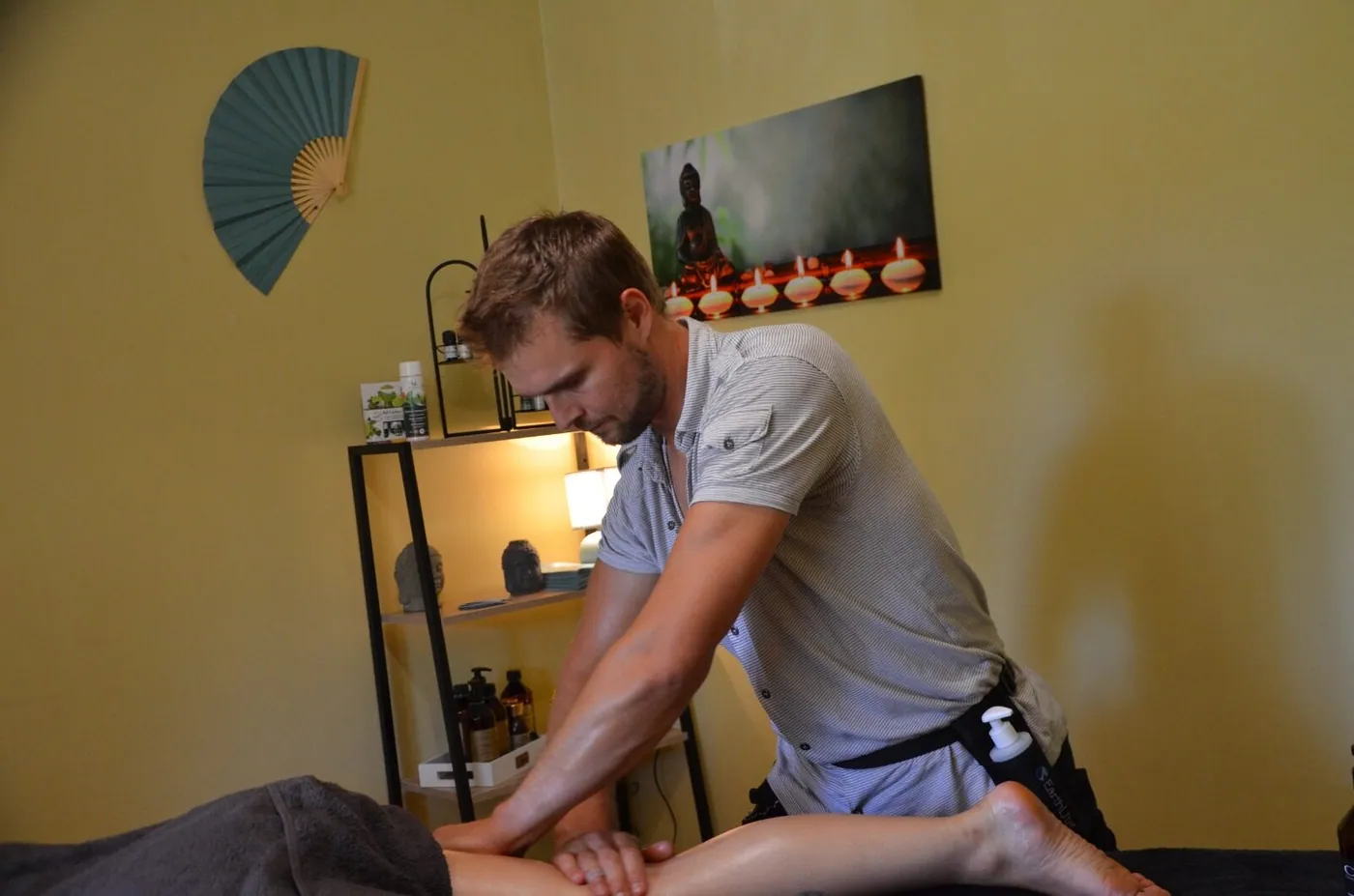 Nicolas en pleine séance de massage dans son salon, lumière chaleureuse