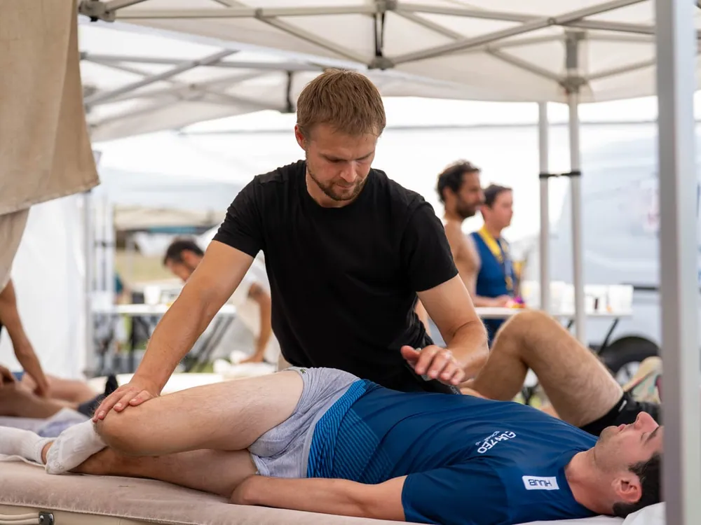 Mobilisation de la jambe d'un athlète juste après l'épreuve
